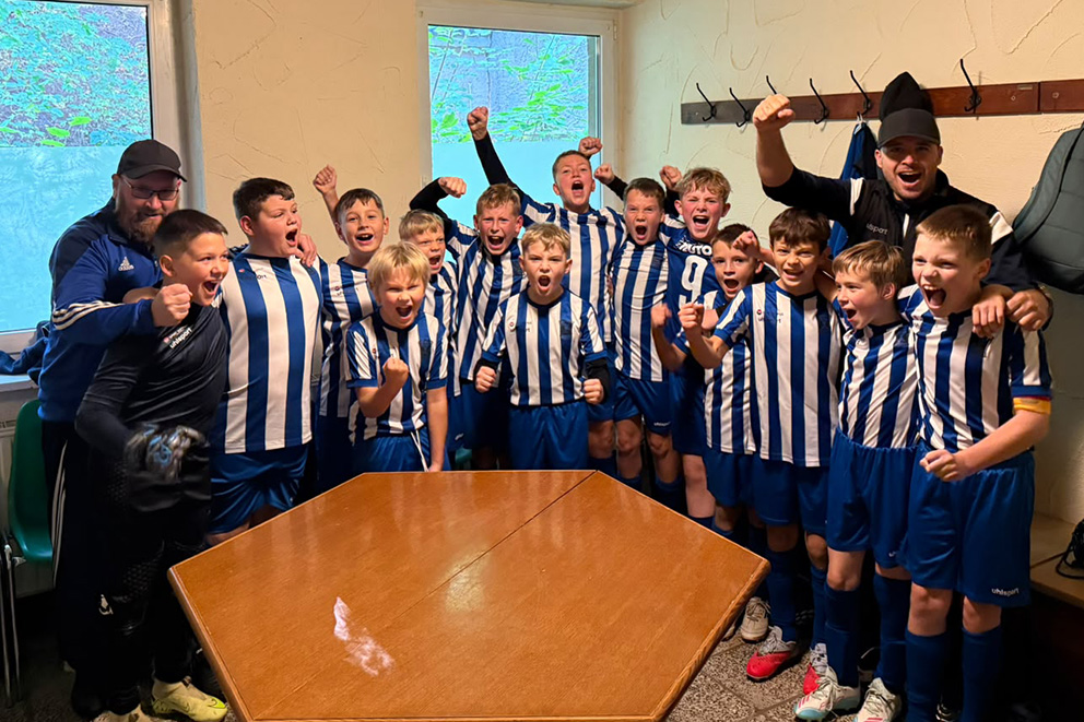 D2-Jugend des FC Hettstedt mit Spielern und Trainern jubelnd in der Umkleidekabine