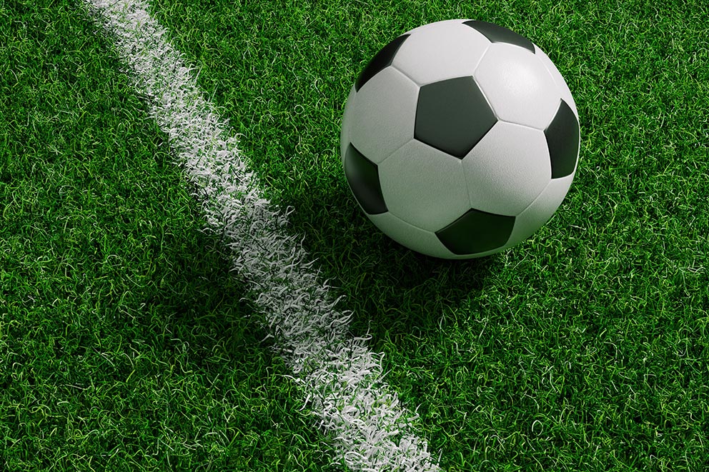Fußball auf Kunstrasen neben einer weißen Spielfeldlinie